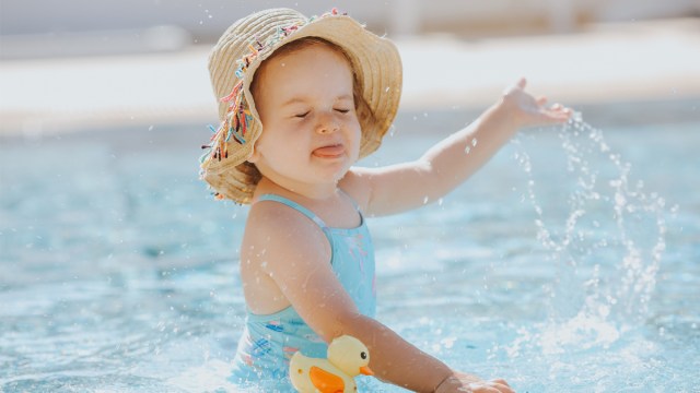 a Pisces baby playing in the water showing her big personality for a story on baby astrology