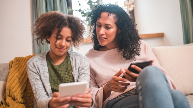 A tween girl on the couch teaching her mom about Italian brainrot.
