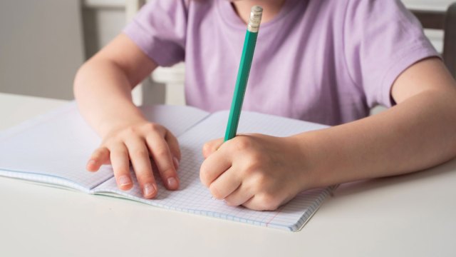 little girl writing with her left hand