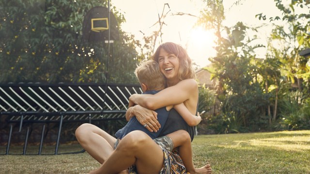A mom who has stopped sharing kids online online giving her son a huge hug in the backyard