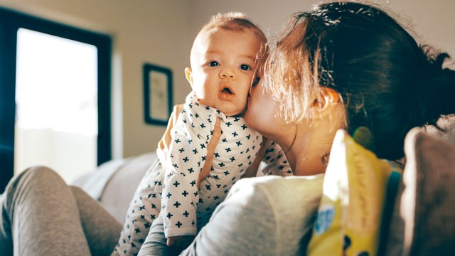 mom kissing a super tired baby who is going through a sleep regression