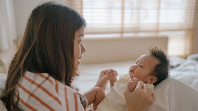mom singing nursery rhymes to her new baby