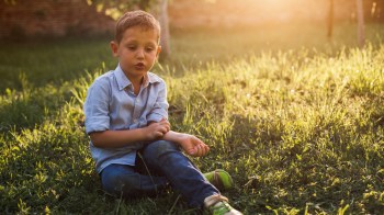 kid scratching his arm from mosquito bite