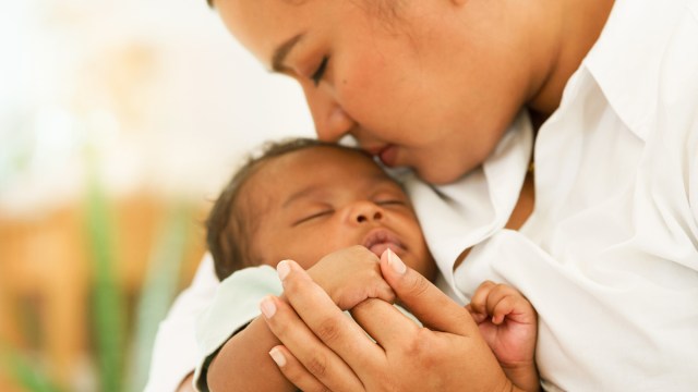 a mother cradling her newborn baby while willing protect them from anything, including respiratory viruses