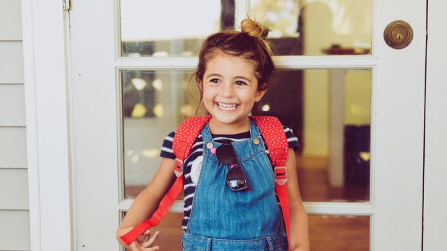a little girl posing on the first day of school outside her house for a story on sharenting