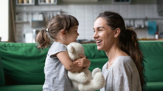 a toddler activities with stuffed animals, girl hugs stuffed animal she found while her mom laughs