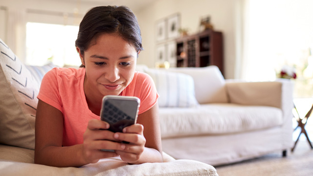 tween girl at home with smartphone
