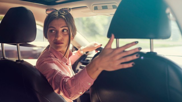 woman looking behind in the car