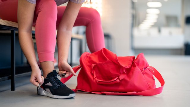 woman tying her shoes at the gym